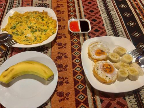 due piatti di cibo per la colazione con una banana e delle uova di Pá Hideaway - Thác Bản Giốc- Cao Bằng a Trùng Khánh