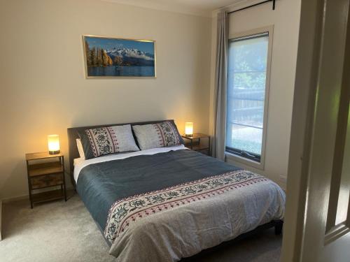 a bedroom with a bed and a large window at Your Leafy Ivanhoe Retreat in Melbourne