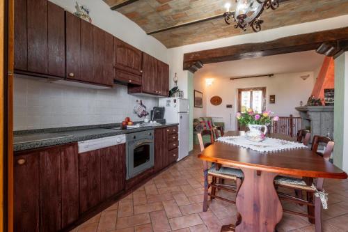a kitchen with wooden cabinets and a wooden table in a kitchen at le stanze della Terrazza sul Borgo in Castel del Piano