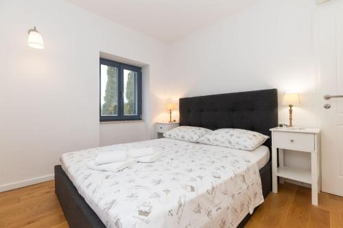 a bedroom with a large bed with a black headboard at Apartments Rialto in Veli Lošinj