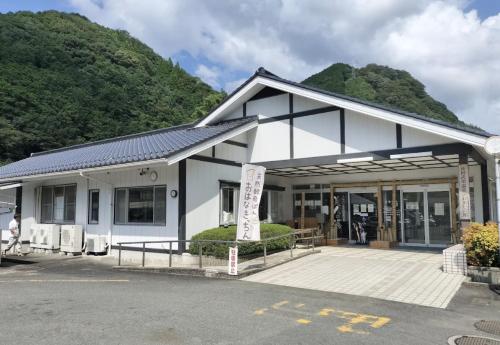 een wit gebouw met een berg op de achtergrond bij STEP HOUSE -The river side- in Hagi