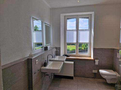 a bathroom with a sink and a toilet and windows at Ferien im Denkmal in Sundern