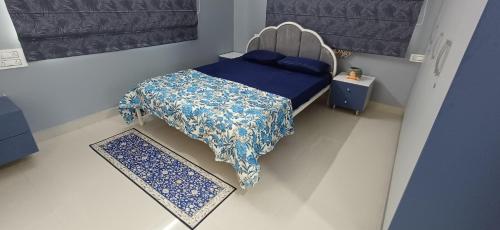 a small bedroom with a bed with a blue comforter at 'Tatvamasi' Farmstay, Hillock The Nature Retreat, Vikarabad in Morangpalli