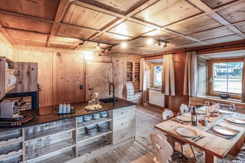 een keuken met houten wanden en een tafel met stoelen bij Chalet Bauernhaus 1864 in Elbigenalp