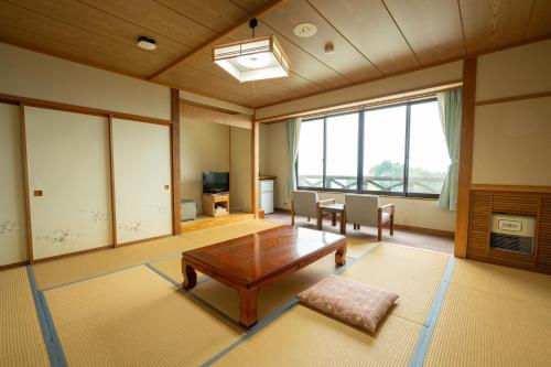 a large living room with a table and chairs at 星と緑のロマン館 in Ogawa
