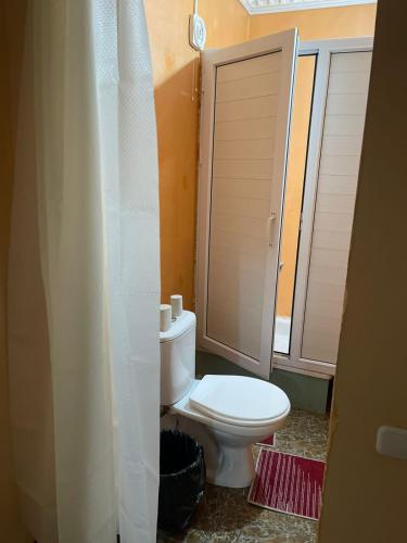 a bathroom with a toilet with a shower curtain at Anissa in Shymkent