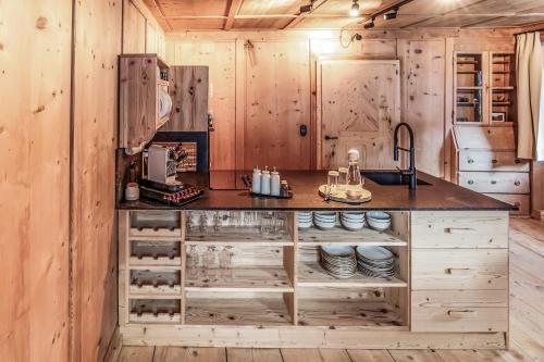 een keuken met houten wanden en een aanrecht met borden bij Chalet Bauernhaus 1864 in Elbigenalp
