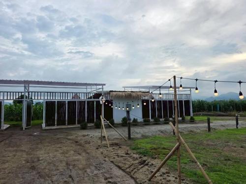 a building with lights on it in a field at LeLaNa Farmstay Camping in Pak Chong