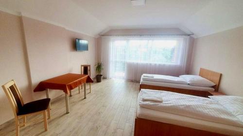 a room with two beds and a desk and a window at Penzion rodina in Chornice