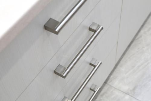 a pair of metal handles on a white cabinet at EmilyApartments 1 in Chrysoupolis