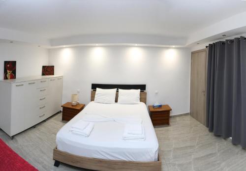 a bedroom with a large white bed with two towels at EmilyApartments 1 in Chrysoupolis