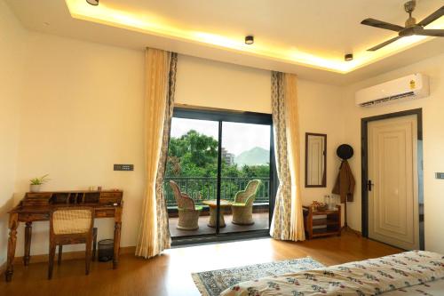 a bedroom with a bed and a desk and a window at Moti Villa in Jāmb