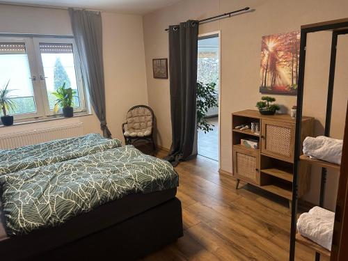 una camera con letto, cassettiera e finestre di Ferienwohnung Schönheit a Gönnern