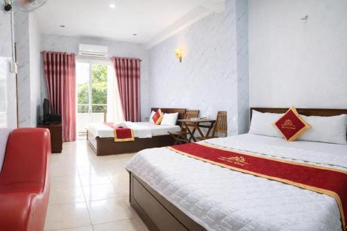 a hotel room with two beds and a table at Duy Khang 1 Hotel in Ho Chi Minh City