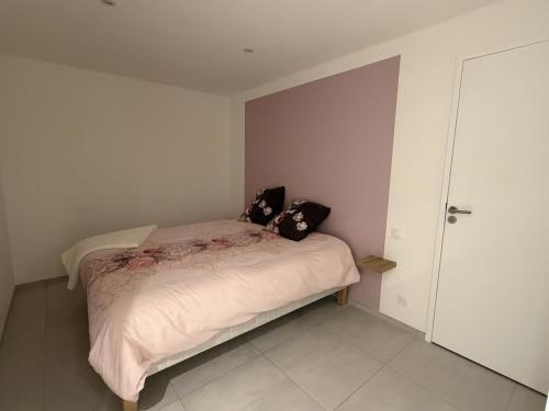 a bedroom with a bed with two pillows on it at Murmure de rose in Rosnoën