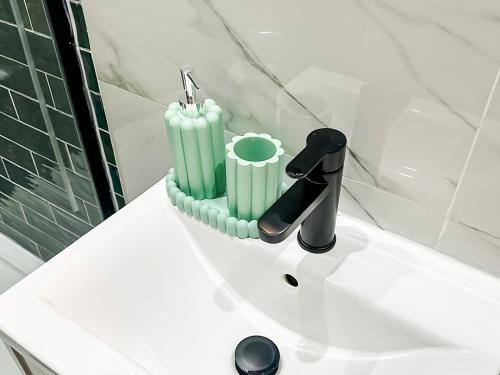 a bathroom sink with a faucet and a candle on it at City Spacious Apartment in Central Station