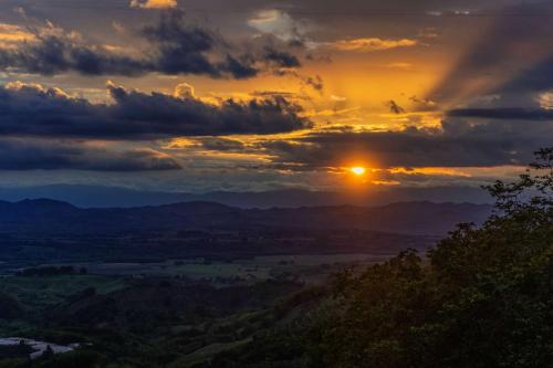 a sunset in the mountains with the sun setting at Casa Margarita Loft in Buenavista