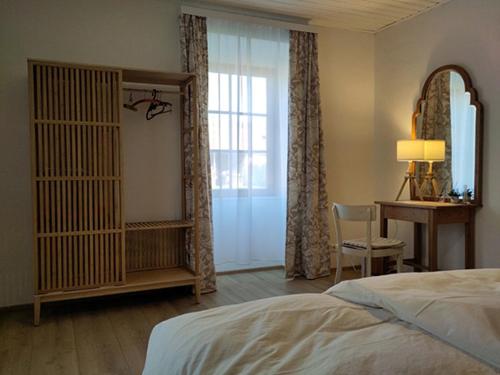 a bedroom with a bed and a desk and a window at Wohnen im Meierhof in Hohenwarth