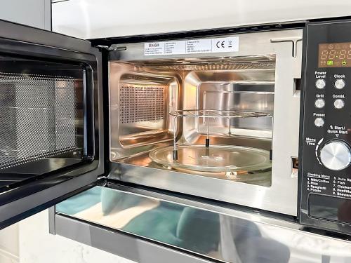 a toaster oven with its door open with a tray inside at City Spacious Apartment in Central Station