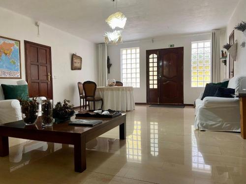 een woonkamer met een tafel en een bank bij Casa de Azzancha in Azinhaga