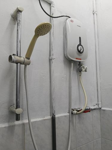 een douchekop en een föhn aan de muur bij Homestay Sayang in Ipoh