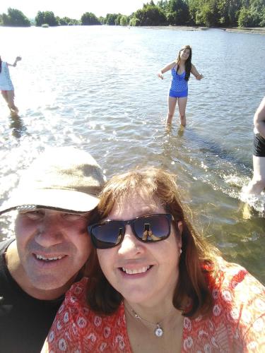 a man and a woman standing in the water at Coyunche Cabañas y Camping Laja & San Rosendo in Laja