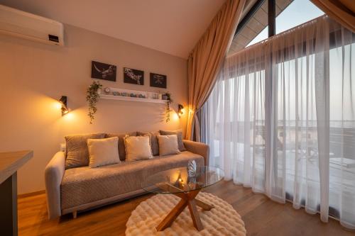 a living room with a couch and a glass table at Rekreačné domy Marina Cabin House in Bobrovník