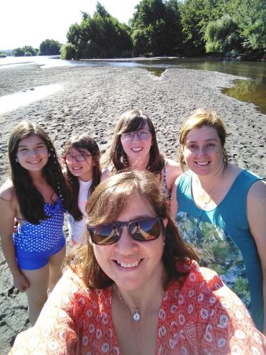 a group of women posing for a picture on the beach at Coyunche Cabañas y Camping Laja & San Rosendo in Laja
