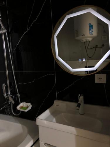 een badkamer met een spiegel boven een toilet en een wastafel bij Royal in Osh