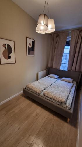 a bedroom with a bed and a window at Apartament Skarbowa 2 in Leszno