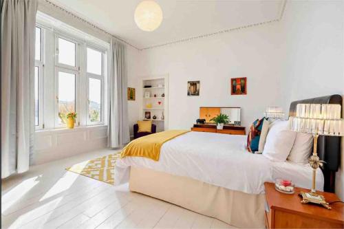 een witte slaapkamer met een groot bed en een raam bij Dairsie Sea View in Rothesay