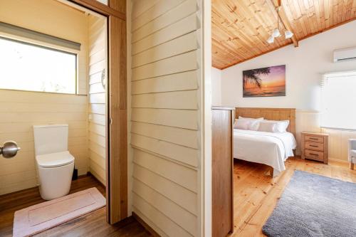 a bedroom with a bed and a toilet in a room at Bonnie Brae Retreat in Swansea