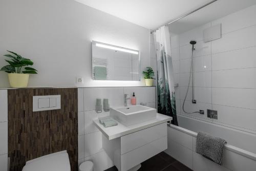 een witte badkamer met een wastafel en een douche bij Chasa Valbernard 4105 in Vulpera
