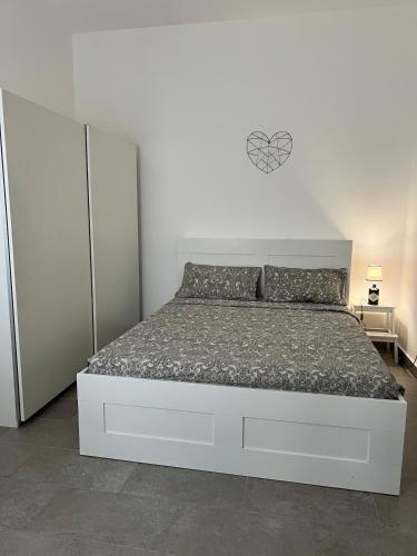 a white bedroom with a large bed with a white wall at SantegidioHomeCesena in Cesena