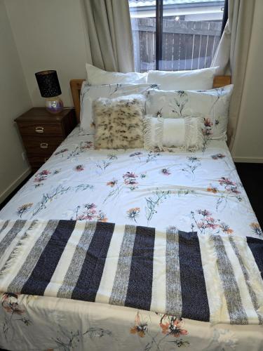 a bed with a quilt and pillows on it at Four-bedroom house in Gungahlin