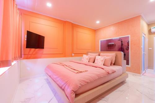 una camera da letto con un letto grande e una TV a schermo piatto di บ้านพวงชมพูเกาะล้าน a Ko Larn