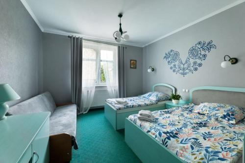 een slaapkamer met 2 bedden en een bank bij Villa Polka in Kudowa-Zdrój