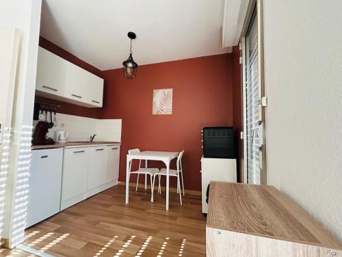 a kitchen with white cabinets and a table with chairs at Bel Air Appartement in Niort