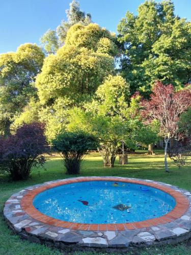 una piscina circolare in un cortile con alberi sullo sfondo di Casa de Campo Brandsen - Quinta La Mandarina a Brandsen