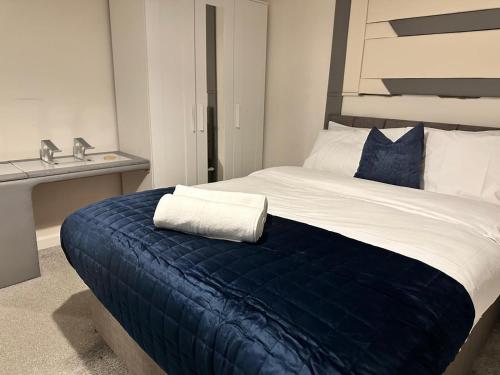 una camera da letto con un letto grande con una coperta blu di Spacious Luxurious Serviced Accommodation 5 a Bushbury