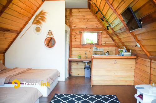 a room with two beds and a sink in a cabin at Quenz Cabin By Travelink in Dieng