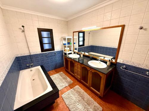 a bathroom with two sinks and a tub and a mirror at Villa Marée La Costa in La Costa