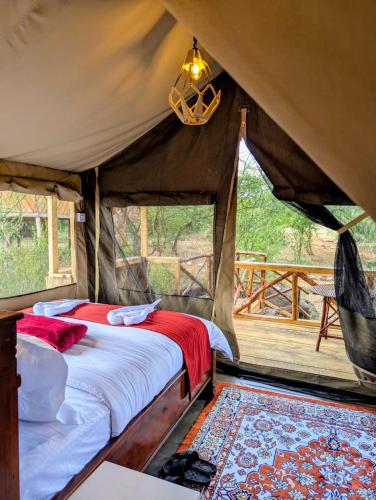 a bedroom with a bed in a tent at Olemayian Amboseli Cottages in Amboseli