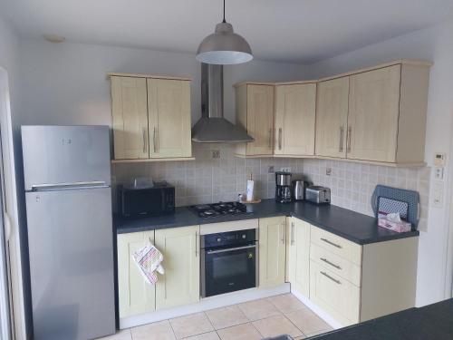 een keuken met houten kasten en een witte koelkast bij Maison 400m de la mer in Pénestin