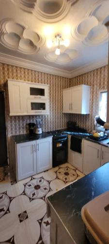 a kitchen with white cabinets and a patterned floor at BTourays Rentals in Yundum