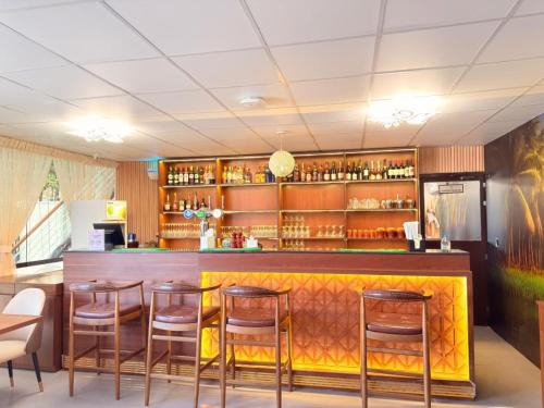 a bar with wooden stools and a counter in a restaurant at Boutique Hotel in Fujairah