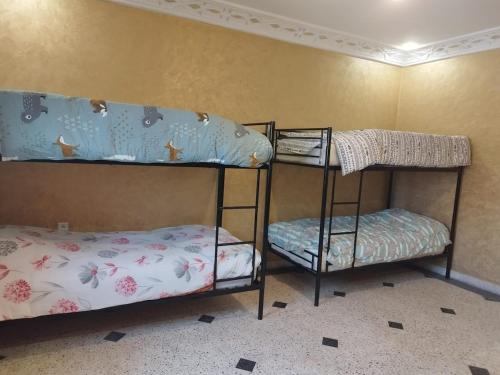 two bunk beds in a room with a bed at Luxurious mountain villa avec wifi in El Ksiba