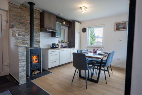 een keuken en eetkamer met een tafel en een open haard bij D.I.M. Holiday House in Seliste Dreznicko