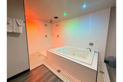 a bath tub in a bathroom with rainbow lights at The Queen B Motel, Detroit-Warren in Warren