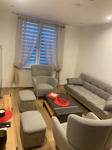 a living room with a couch and chairs and a table at Apartament Nowa in Jarocin